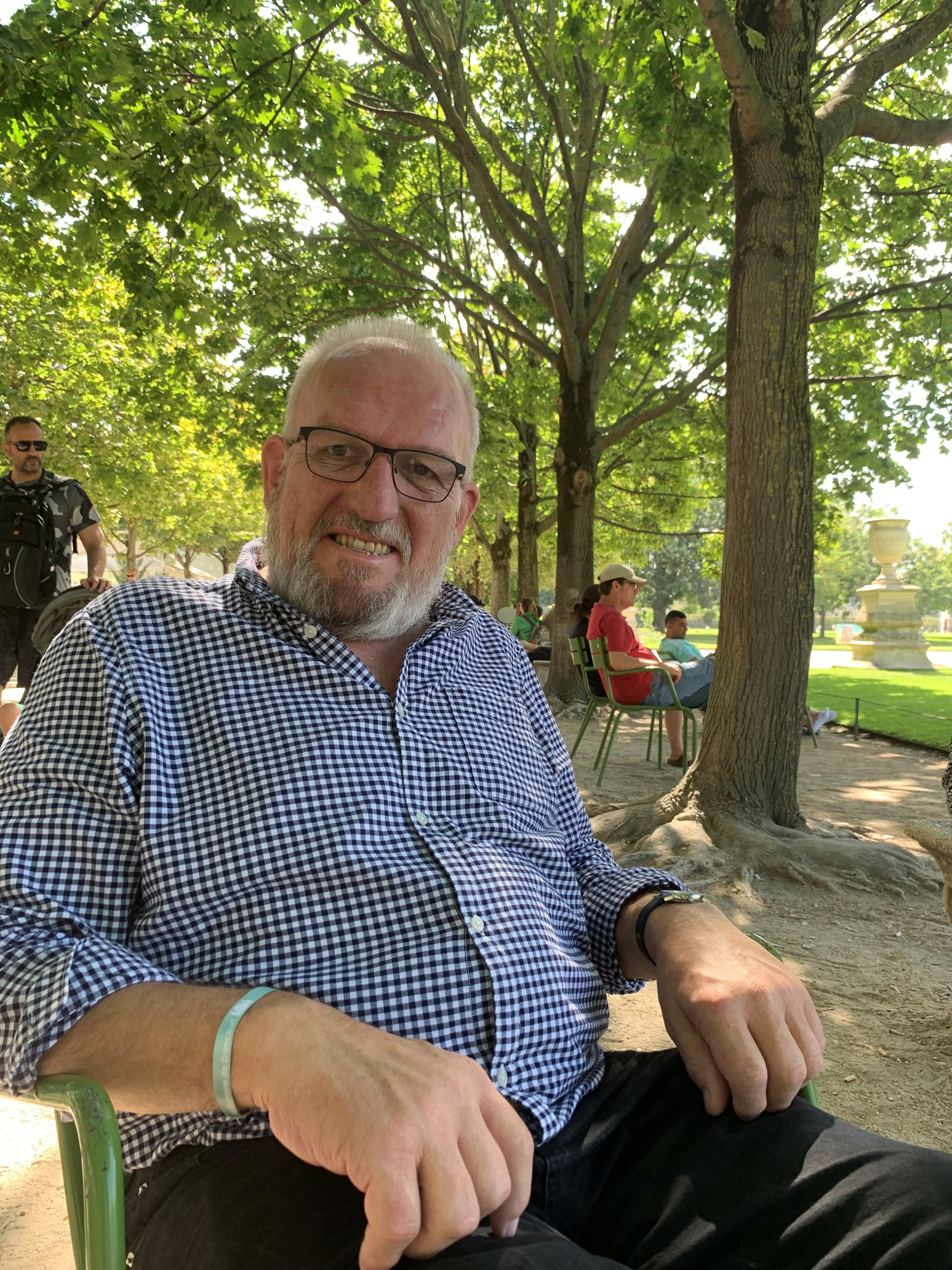 Chris Maclean, sitting in a chair in woodland