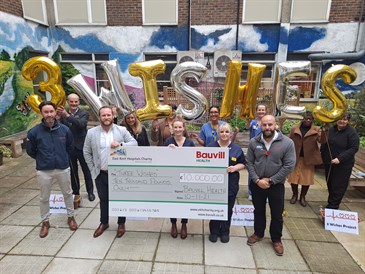 3 Wishes launch photo. It is a group shot of people in a courtyard garden, holding balloons spelling out 3 Wishes. They are also holding a giant cheque for £10,000