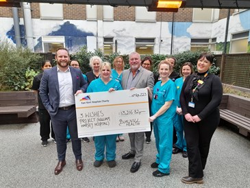Group photo of critical care and charity staff with representatives from Bauvill, who held a charity ball to raise money for the 3 Wishes Project. They are pictured in the critical care garden at WHH holding a giant cheque