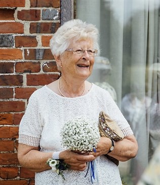 Amanda Voizey, stalwart of the QEQM league of friends, who has died. She is pictured wearing white, standing in front of a wall, and appears to be laughing