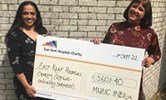 Avatar of Dee Neligan receiving a cheque from Dr Rema Iyer. Photo shows two woman holding a giant cheque for £5,600