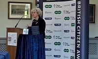 Avatar of Susan Acott speaking at the BCA event. Photo shows Susan at a lectern in front of a BCA backdrop