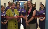 Avatar of Tracey Fletcher and Jess Evans at the opening of the CTU. Image shows Tracey about to cut a ribbon across a corridor, watched by Jess and research staff in purple behind her.