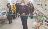 Avatar of the opening of the new dental lab at KCH by Peter Briggs from HEE. Image shows Peter cutting a ribbon with people behind looking on. The lab has stations set up to look like dentists' chairs with model heads for students to work on.
