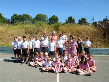 Children from Monkton school who held a sponsored silence for Rainbow Ward. Image shows a class of children sitting outside wearing school uniform.