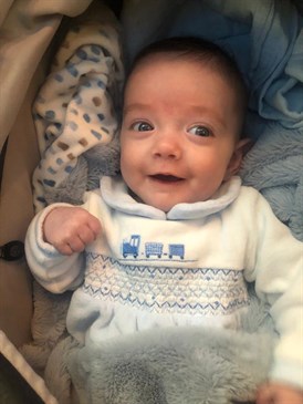 Enzo Alexander now - image is of a smiling baby. He is aged six months but looks around three months