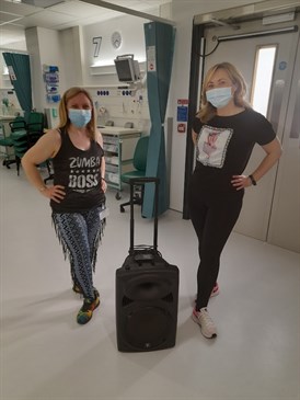 Jeanette Stanford and Iwona King after the Zumba session. They are pictured wearing exercise clothing; Jeanette's top has a message about Zumba on it. Both are wearing surgical facemasks and between them is a portable music player