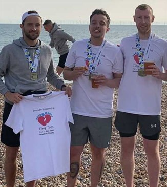Joe, Anthony and Aaron, who ran the Brighton marathon for the Tiny Toes appeal. They are pictured on a beach wearing running gear.