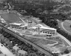 The Kent and Canterbury Hospital in 1936. Black and white image shows a white buildling under construction in a field