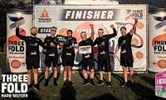 Avatar of Kent Construction Consultants after their charity challenge. Image shows a group of six men wearing black shorts and t-shirts standing in front of a sign that says finishers. One is holding a certificate