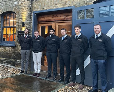 Kent Construction Consultants who are doing the Tough Mudder Challenge. Image shows a group of men standing outside a building