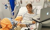 Avatar of Leyton Bridgewater, who features in the trauma documentary Emergency. He is pictured in a hospital bed with a blanket over one leg and a laptop on a table in front of him
