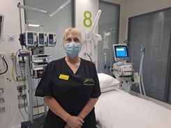 Nichola Shorter, Clinical skills and learning facilitator in Critical Care at WHH. She is pictured wearing scrubs and a mask in a critical care bedspace.