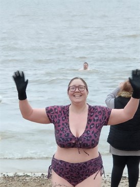 Nicola Oakley who did a fundraising Christmas Day sea swim. Image shows her just emerged from the sea wearing a purple patterned bikini and gloves