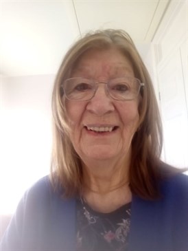 Pat Penny, who had lung cancer and is encouraging people to get symptoms checked early. Photo shows her head and shoulders, she is looking at the camera