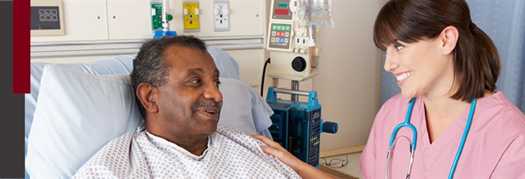 Older male in hospital bed talking with female nurse