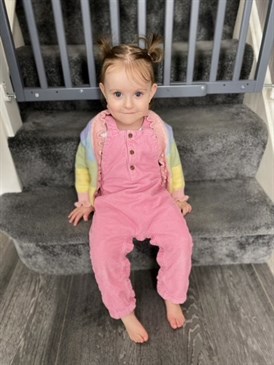Phoenix now - she is a toddler, pictured sitting on the stairs.