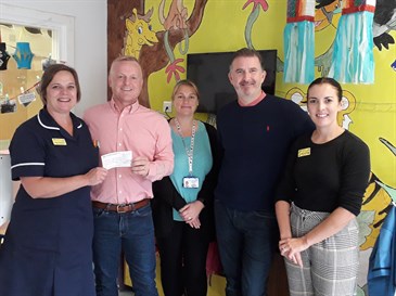 Mr Leitch and main sponsor Jess Roullier presenting the cheque to staff on Rainbow Ward