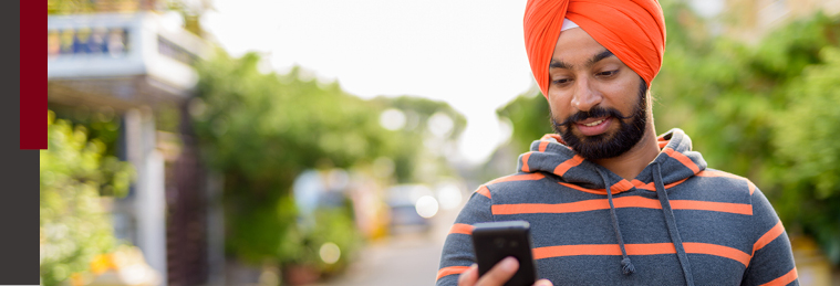 Young Sikh man looking at his phone