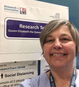 Sharon Turney, a research assistant helping with the elderberry trial who has also had Covid-19 twice. She is pictured by a sign saying Research team QEQM