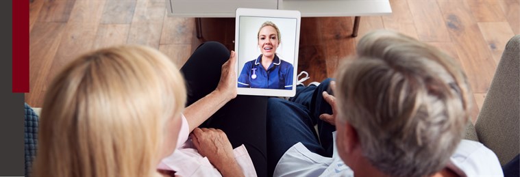 Two people at home talking to a nurse via their tablet