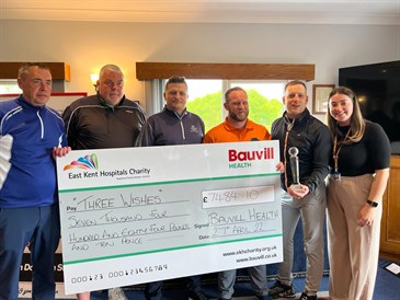 The Bauvill golf day. Image shows a group of people holding a giant cheque. One is also holding a trophy