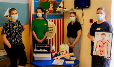 The children's diabetes team with some of the equipment funded by East Kent Hospitals Charity. There are four women in the photo, wearing surgical masks. They are pictured with a table that has equipment on it. One is also holding a board with a diag