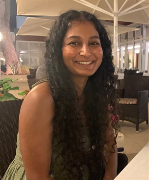 Thirushika Sathialingam, a junior doctor at the QEQM who died in a drowning accident. She is pictured in a restaurant, smiling at the camera.