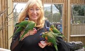 Avatar of Valerie Blankhart. Image shows Valerie holding three exotic birds. She is smiling at the camera.