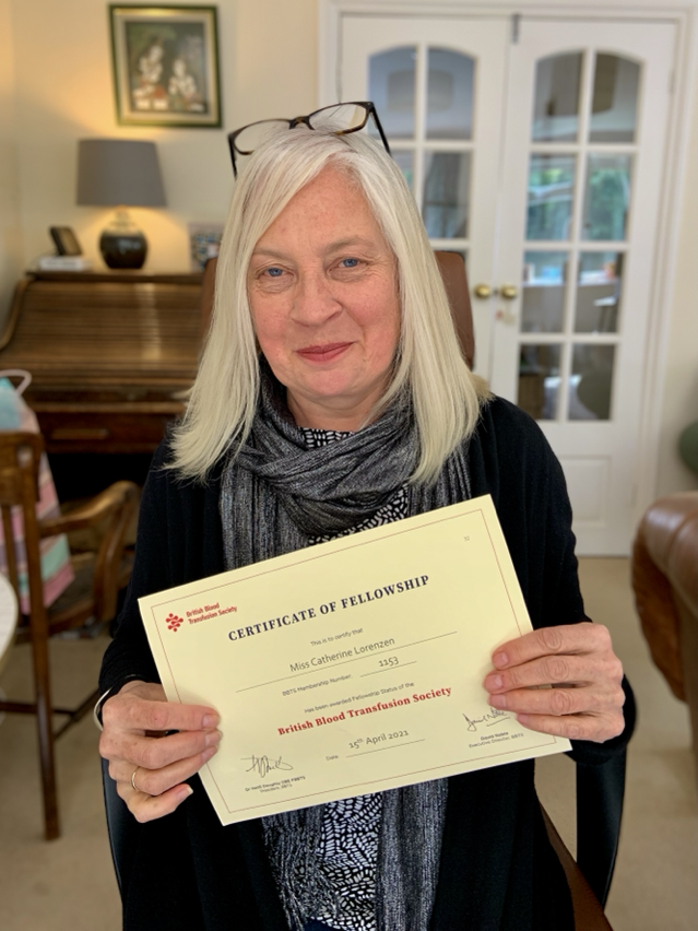 Catherine Lorenzen, holding a certificate of fellowship