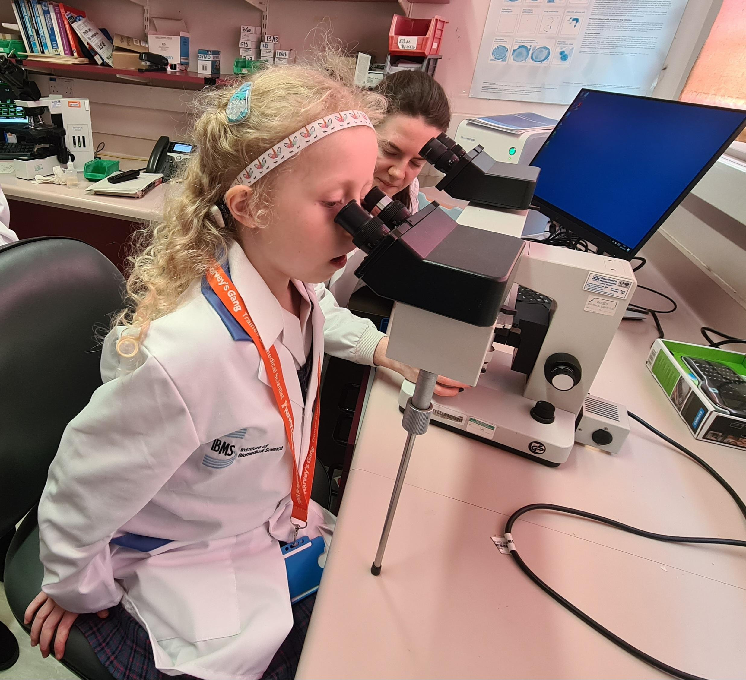Elodie looking at blood samples through a microscope