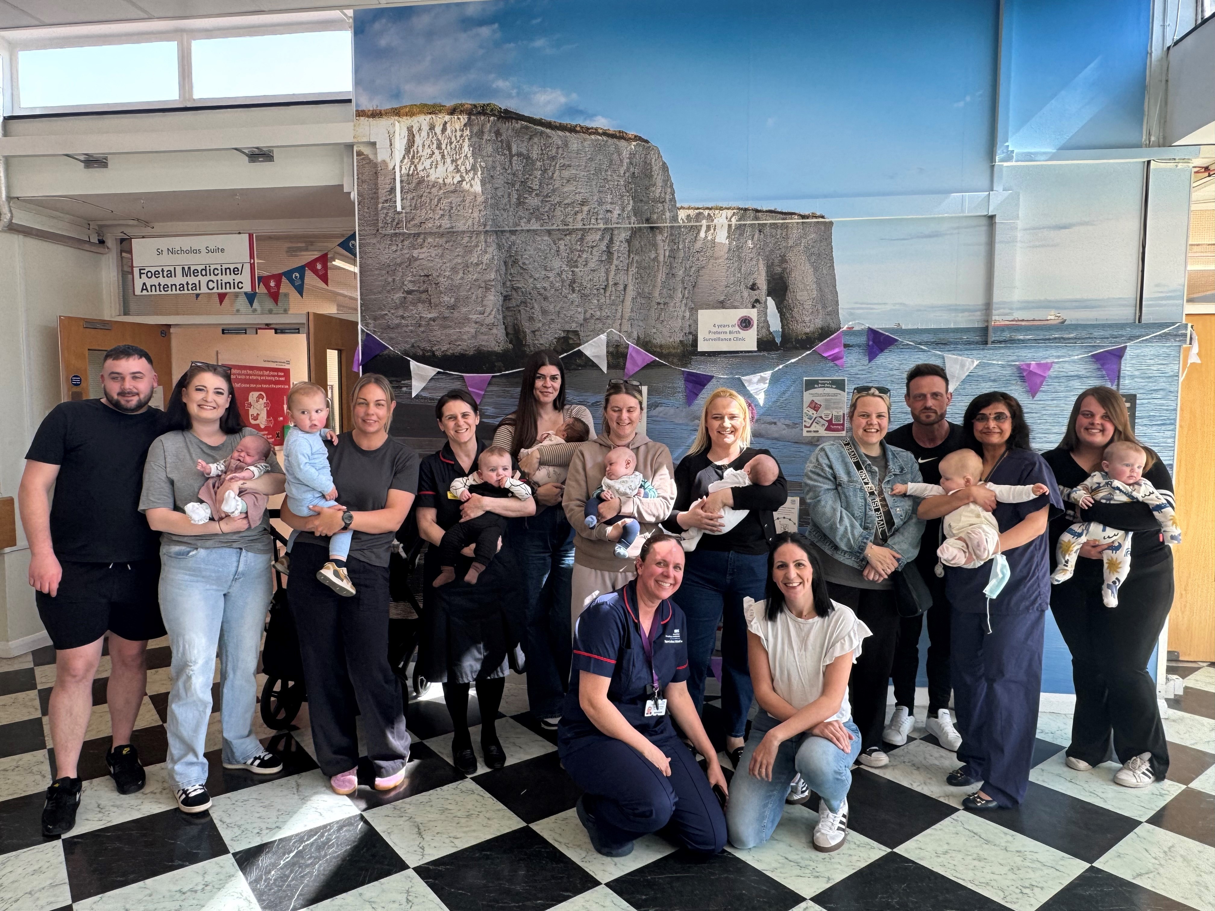 Families who gathered to celebrate the anniversary of the clinic - pictured with staff