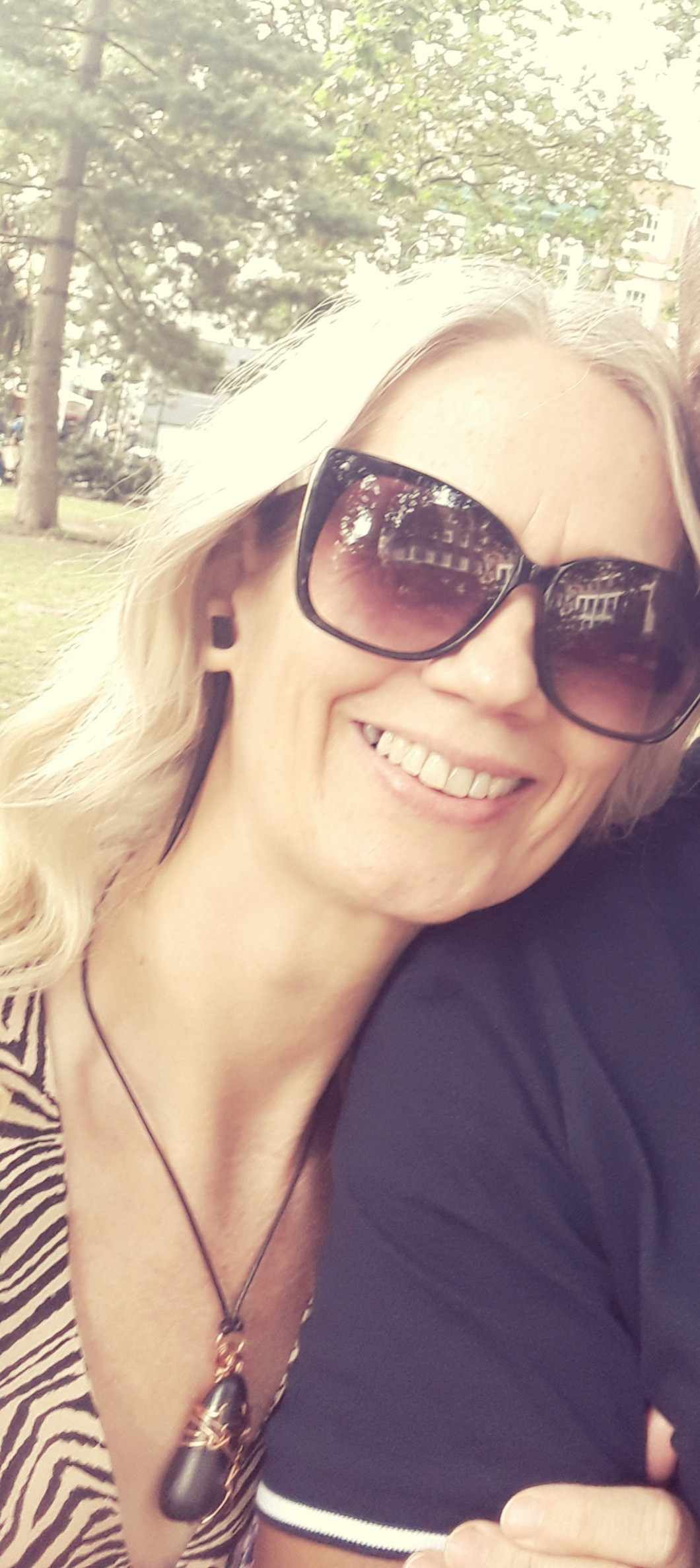 Georgia Randall, who had thyroid cancer. She is wearing sunglasses and leaning on an unseen person's shoulder