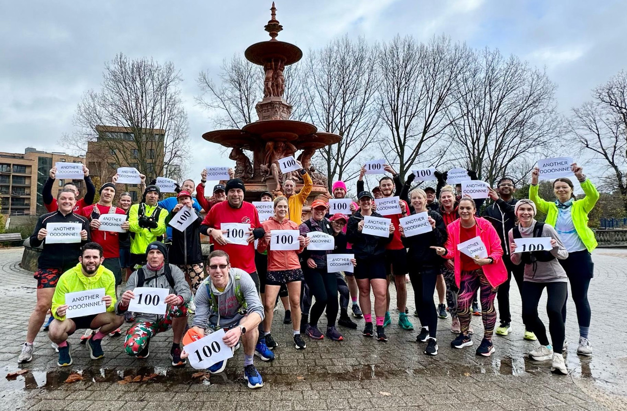 Rob with members of the Ashford Striders running club - they are holding signs with 100 on