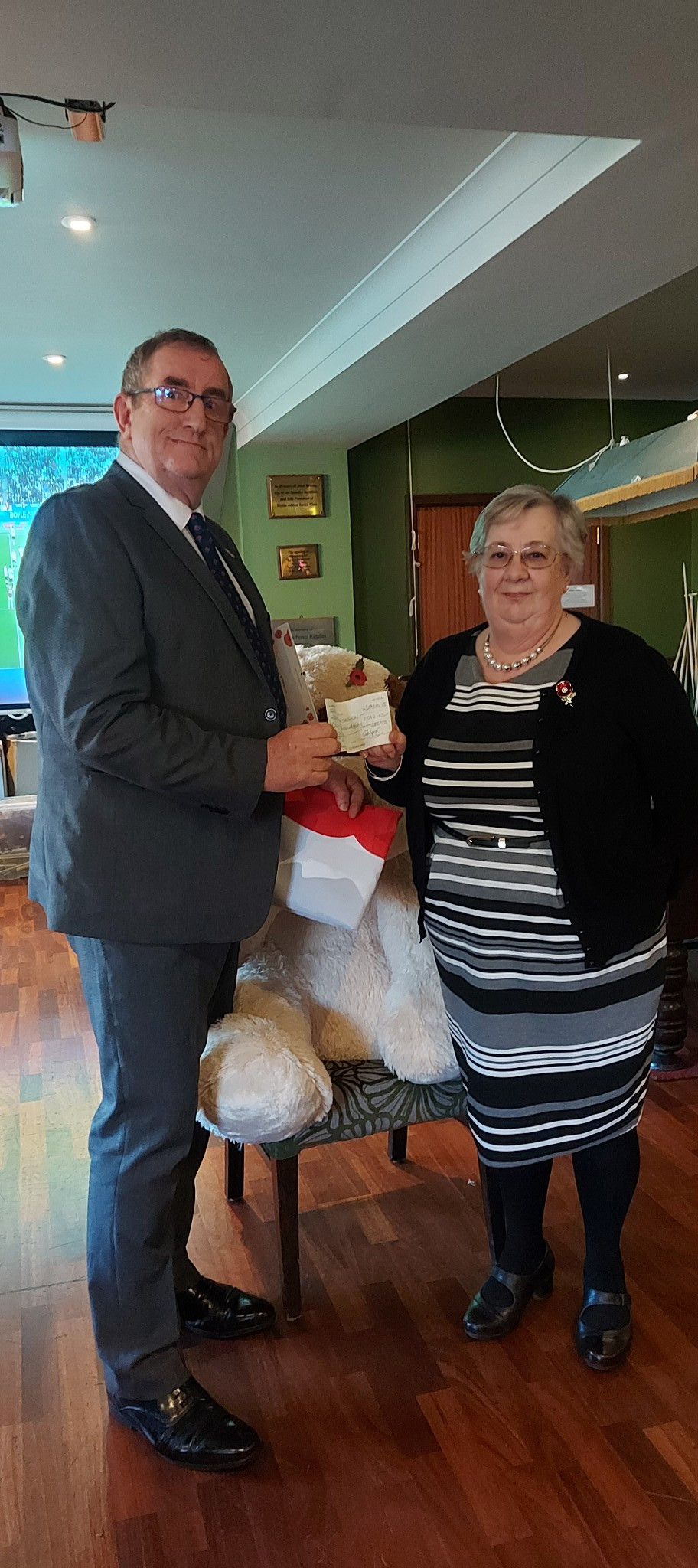 Susan handing over a cheque to the Poppy Appeal and wearing the brooch