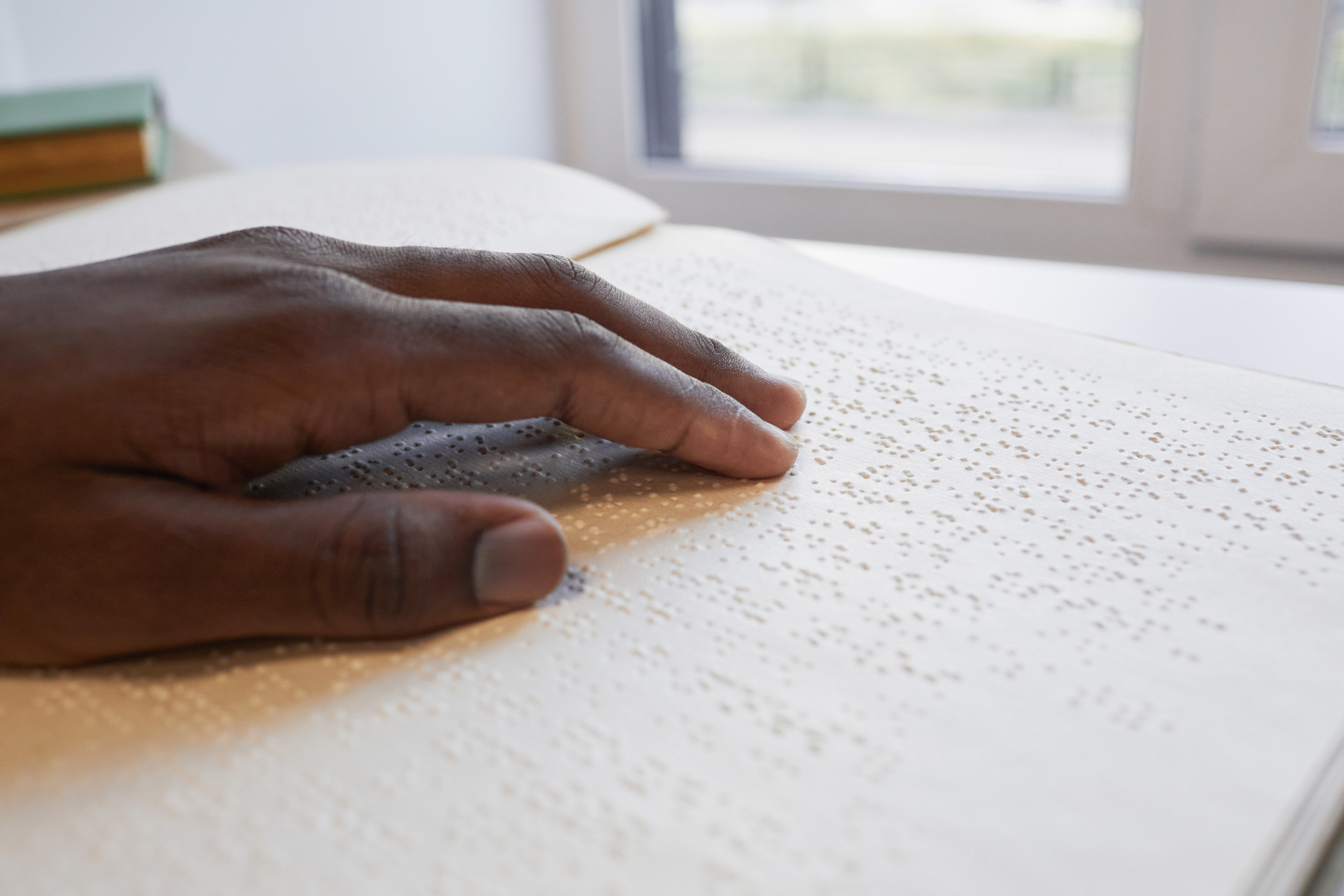 A hand reads braille