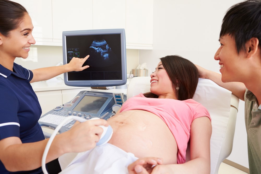 Pregnant woman and partner having an ultrasound baby scan