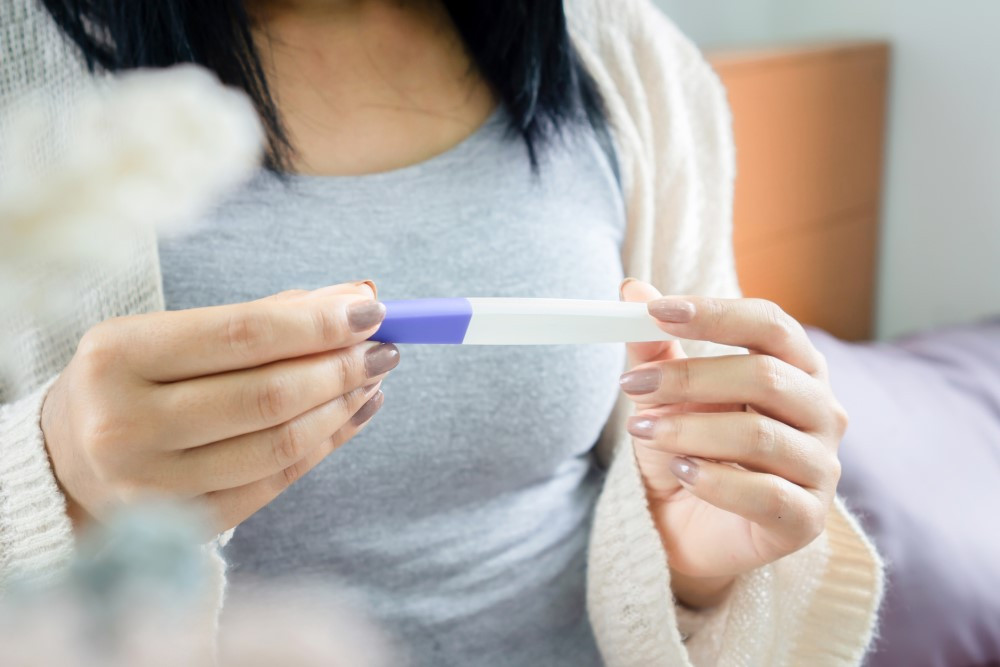 Woman looks at a pregnancy test