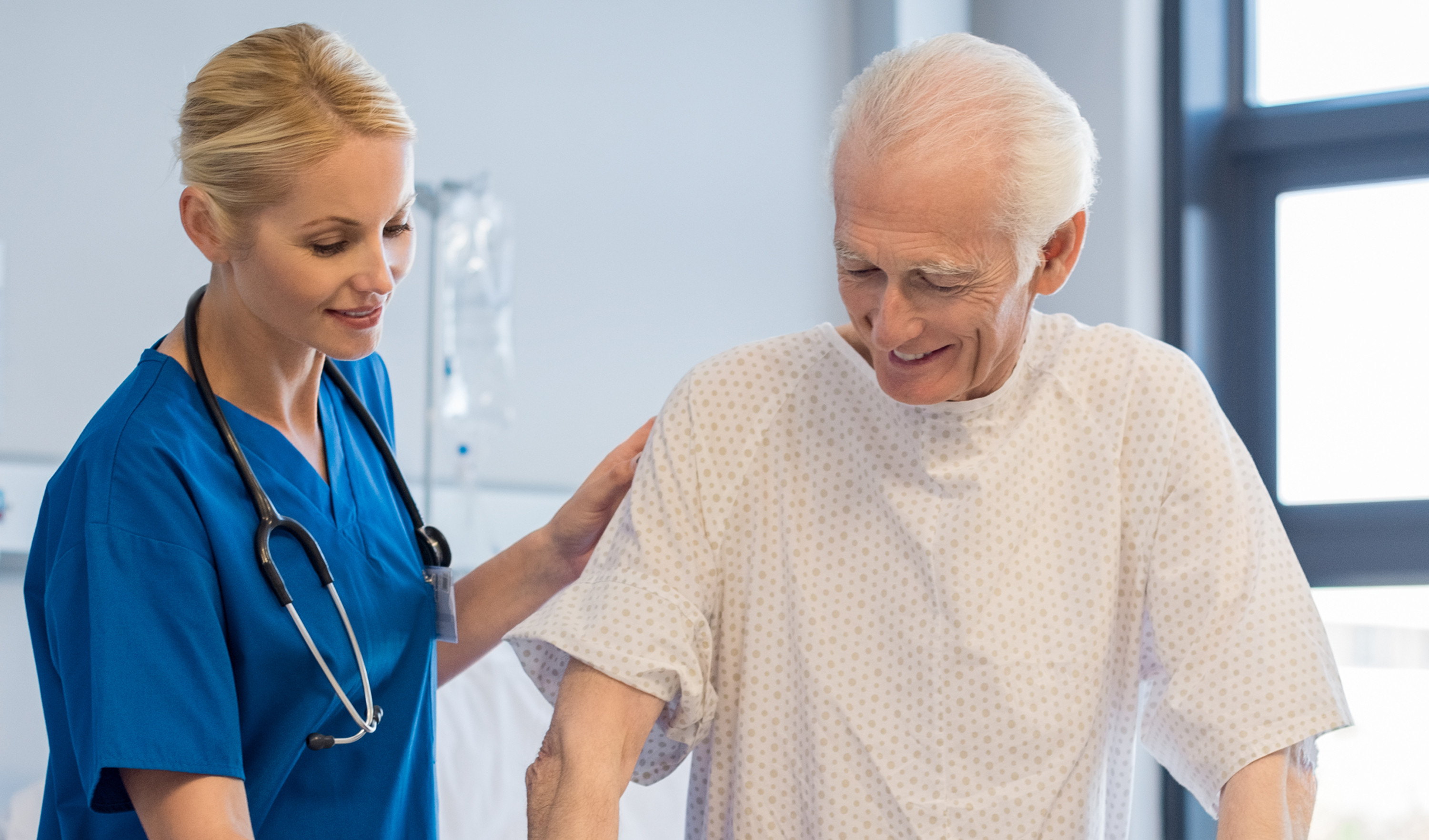 An elderly man being helped by a nurse