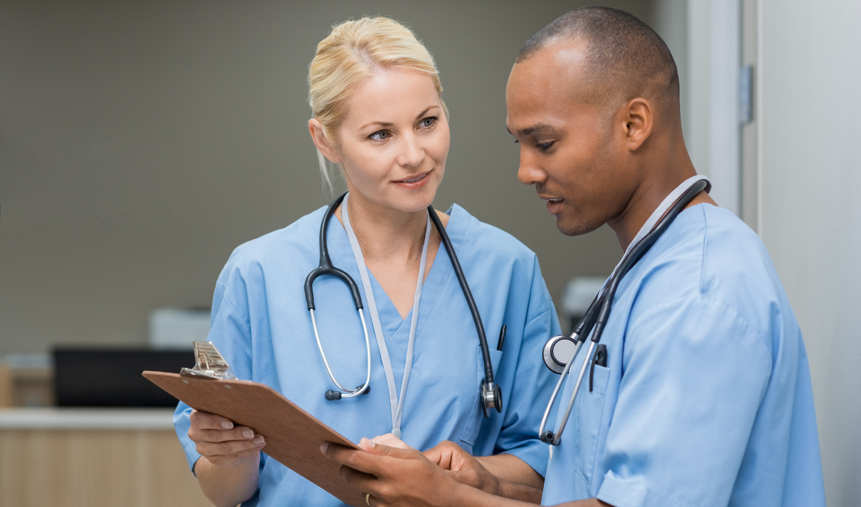 Two nurses look at a clipboard